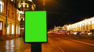 bir akşam sokaklarda yeşil bir ekran ile bir Pano