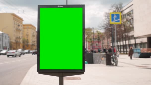Eine Plakatwand mit grünem Bildschirm an einer belebten Straße — Stockvideo