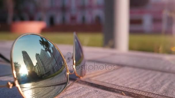 La reflexión de la ciudad en las gafas de sol de cristal — Vídeo de stock