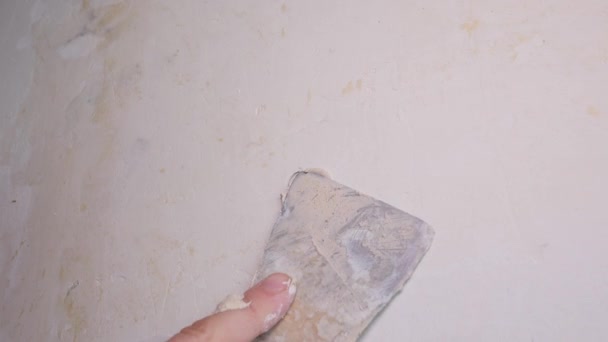 Trabajador aplica yeso a la pared con una espátula — Vídeo de stock
