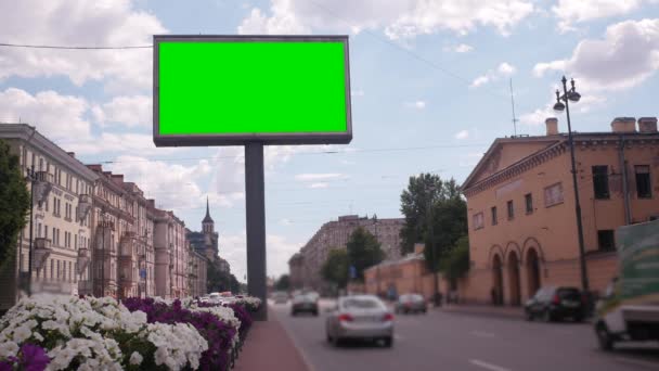 Een bord met een groen scherm op een drukke straat — Stockvideo