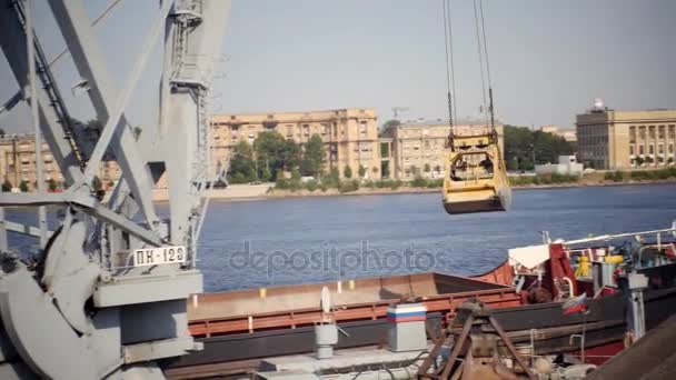 la grue de chargement décharge la pierre concassée de la péniche à la jetée .