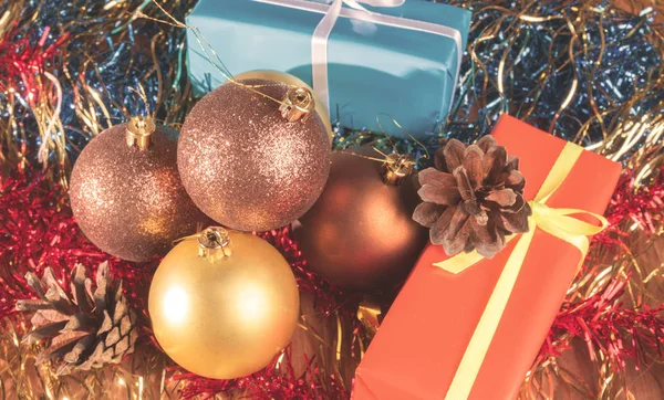 De giften van Kerstmis onder de ballen en het klatergoud — Stockfoto