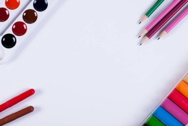 Kalem, kurşun kalem, boya kalemi ve kil bir kağıdın köşelerinde yalan