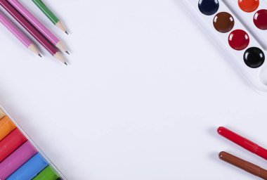 Kalem, kurşun kalem, boya kalemi ve kil bir kağıdın köşelerinde yalan