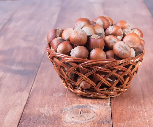Hazelnuts in a basket on a wooden table — Stock Photo, Image
