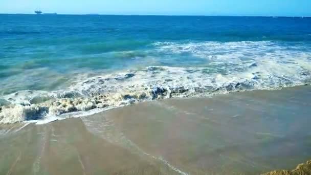 Ondas batendo em uma praia de areia — Vídeo de Stock