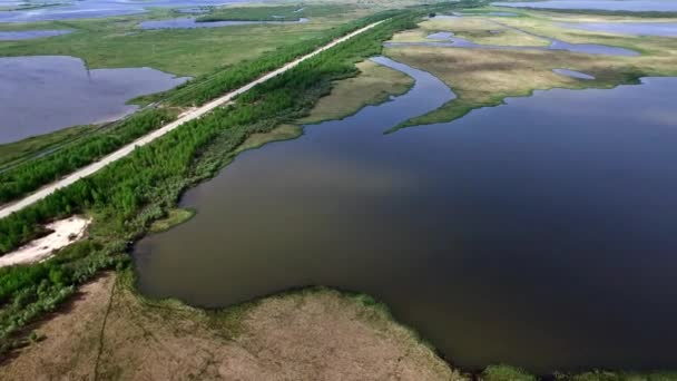 Vista aérea da estrada que passa entre os lagos . — Vídeo de Stock