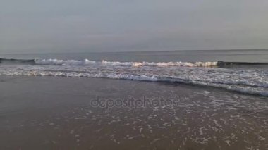 Dalgalar akşam plajda çalışan.