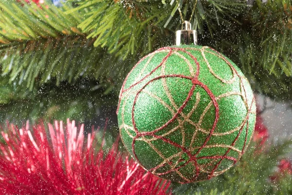 Πράσινη Χριστουγεννιάτικη μπάλα σε ένα υποκατάστημα και το χιόνι που υπάγονται — Φωτογραφία Αρχείου