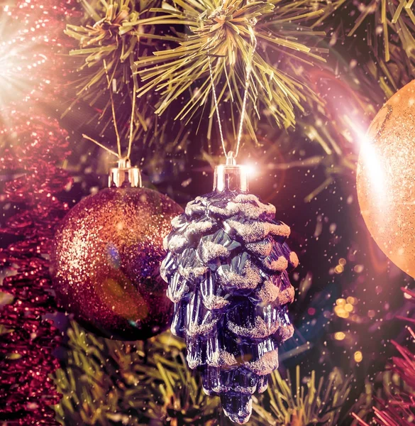 Juguetes de árbol de Navidad en una rama con reflejos en un estilo vintage — Foto de Stock