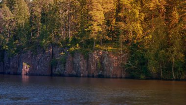 Sonbahar doğası - gün batımında bir kaya ve orman