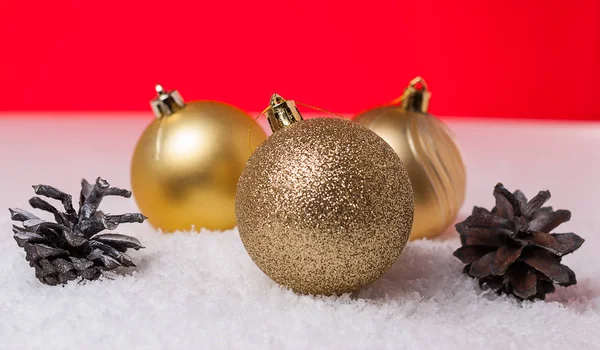 Kegel en kerst bal op een rode achtergrond — Stockfoto
