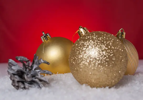 Árbol de Navidad y bola de árbol de Navidad amarillo en la nieve —  Fotos de Stock