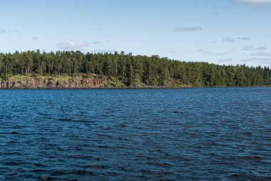 Gün batımında dağ gölü kayalık sahil görünümü. Tekne geçerek gelen görüntülemek