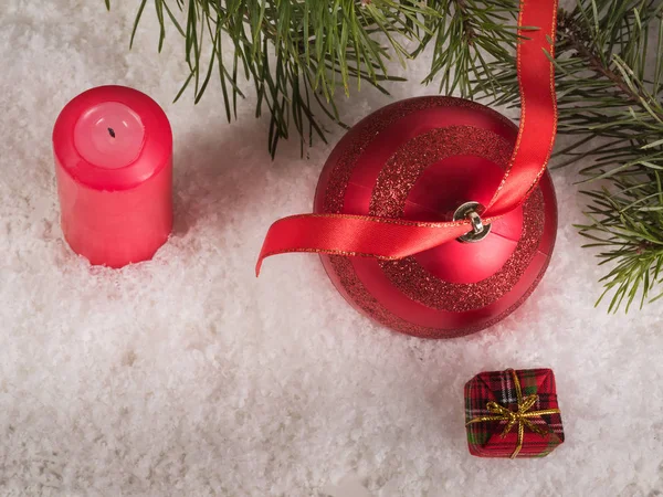 Bola roja de Navidad con cinta, velas y cajas de regalo — Foto de Stock