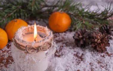 Mum, mandalina ve çam dalları ahşap bir arka plan üzerinde yanan