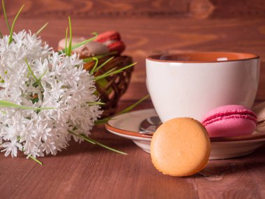 Fincan çay, kek masada ve arka plan üzerinde beyaz çiçekler ile