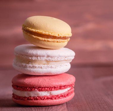 Ahşap arka plan üzerinde renkli macaroons yığını
