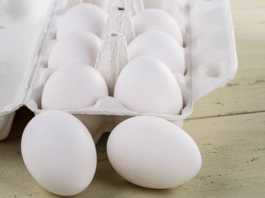 Yumurta ile ambalaj ve yumurta bir ahşap arka plan yanında yalan açıldı