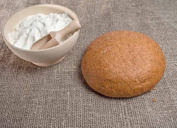 Cereal bread and a bowl of flour — Stock Photo, Image