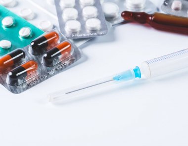 Bir paket ve bir şırınga kopya alanı ile beyaz bir arka plan üzerinde renkli kapsül