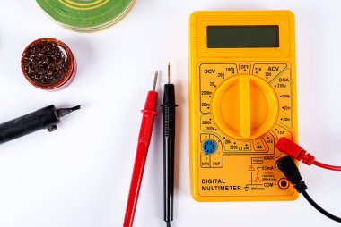 Beyaz zemin üzerinde çoklu metre, tornavida ve lehim demiri.