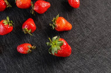 Siyah arka planda taze çilekler.
