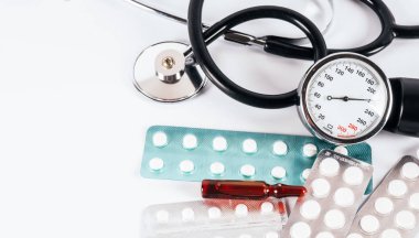 Tıbbi steteskop ve haplar ve vitaminlerle su toplamış.