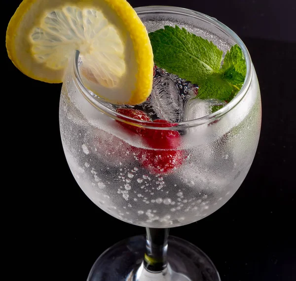 Ein Glas alkoholischer Cocktail mit Kirschen, Limetten und Eis — Stockfoto