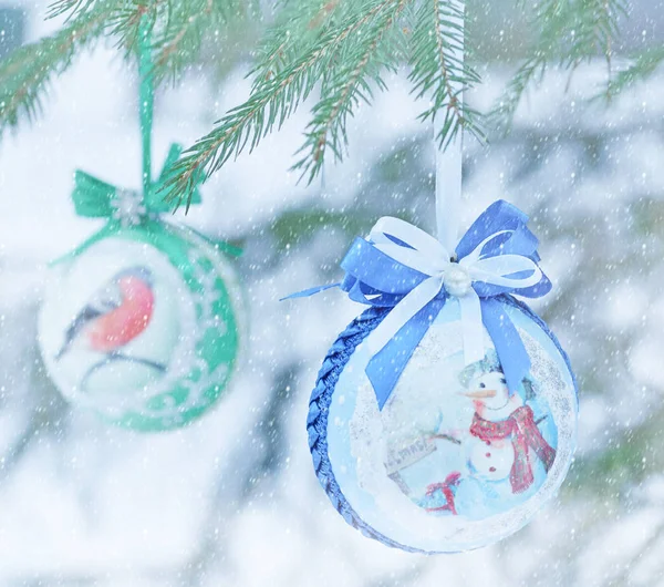 Boules de sapin de Noël suspendues sur des branches d'arbre de Noël dans une forêt d'hiver sous une chute de neige — Photo