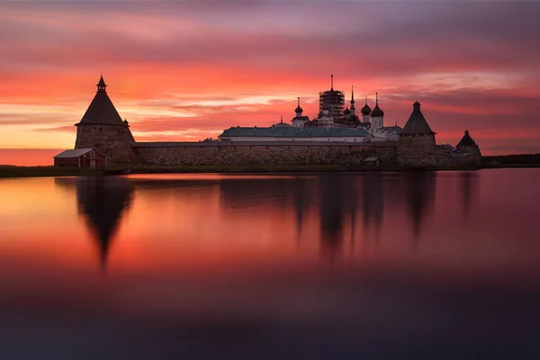 Fantastik güzel ateşli gün batımı üzerinde kutsal göl manzaralı bir Solovetsky Spaso-Preobrazhensky Monastery.Russia.
