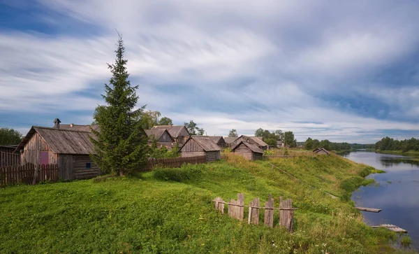 Kuzey Rusya'nın. Nehri Vadisi ve tipik köy evi kırsal kesimde, bulutlu hava yatay yaz. Eski çiftlik evi. Kuzey Rus köy. Kenozerye. Arkhangelsk region, Rusya Federasyonu