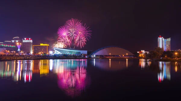 Panorama nocturno de Minsk con un saludo festivo y fuegos artificiales. Centro de la ciudad con vista al río Svisloch, hotel Belarús y avenida Pobediteley . —  Fotos de Stock