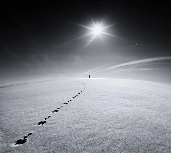 Dünya. Kar kabuk alanında güneş ve uçan uçağın arka plan üzerine bir tavşan izinde yürüyen Universe.Lonely adam. Bir adam kış boş alan de yol silüeti soyut fotoğraf. 