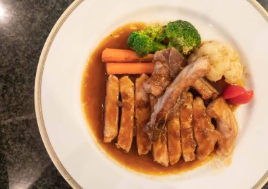 Beyaz tabakta soya soslu ızgara tavuk.