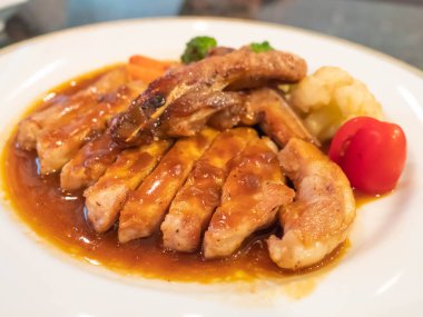 Beyaz tabakta soya soslu ızgara tavuk.