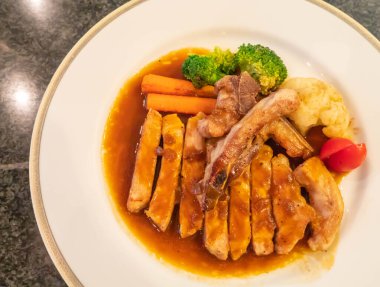 Beyaz tabakta soya soslu ızgara tavuk.