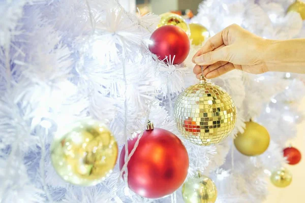 Altın parlak parlak baubles (kristal top disko tarzı) ile portre resim beyaz bir el dekorasyon Noel ağacı. Kavramı ve Noel tatilleri kutlama fikri