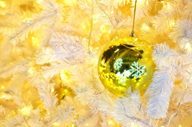 Altın Top önemsiz şey yansıtan kar pul süslenmiş Noel ağacı üzerinde