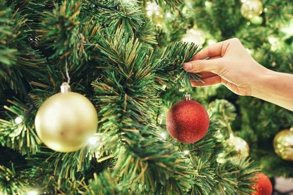 Portre resim kırmızı parlak parlak baubles ile Noel ağacı süsleme el. Kavramı ve Noel tatilleri kutlama fikri