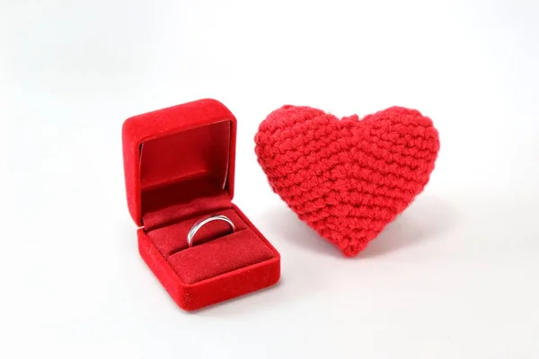 Kırmızı tığ işi kalp ile alyans izole beyaz zemin üzerine bir kutu içinde. Sevgililer günü. Aşk sembolü.