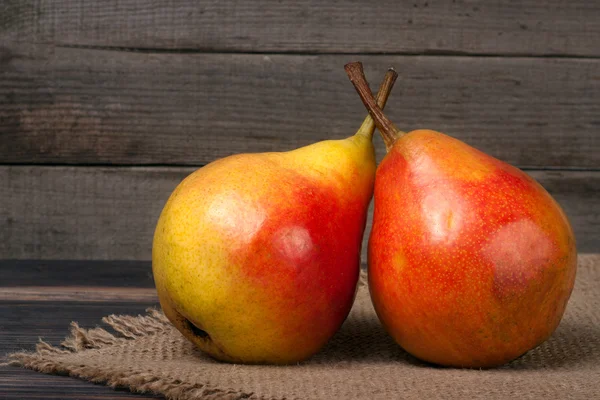 iki tam ve yarım armut kumaş çuval bezi ile ahşap bir masa üzerinde
