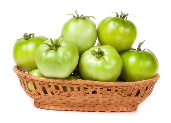 Unreife grüne Tomaten in einem Weidenkorb isoliert auf weißem Hintergrund — Stockfoto
