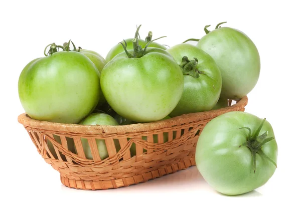 Unreife grüne Tomaten in einem Weidenkorb isoliert auf weißem Hintergrund — Stockfoto