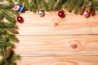 Köşe çerçeve ile ışık ahşap arka plan üzerinde Noel süsleri çam dalı