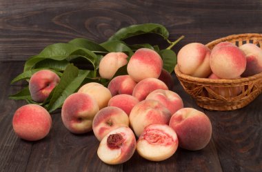 ahşap masa üzerinde bir hasır sepet şeftali