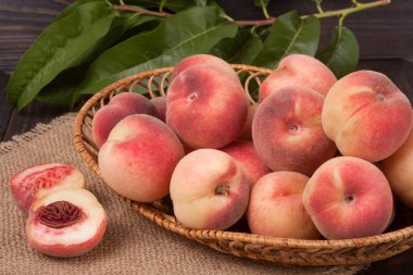 ahşap masa üzerinde bir hasır sepet şeftali