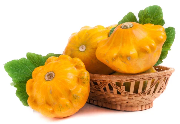 Calabaza pattypan amarillo con hoja en una cesta de mimbre aislado sobre fondo blanco — Foto de Stock