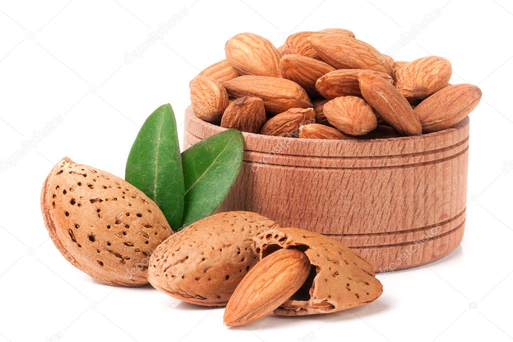 heap of almonds in their skins and peeled with leaf isolated on white background